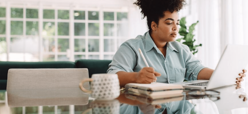 Woman at the dining room table learning 4 Tax Reduction Strategies For People Who Are Self-Employed