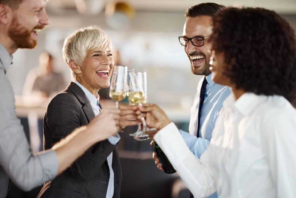 Happy business colleagues having fun while toasting with champagne on a party in the office.