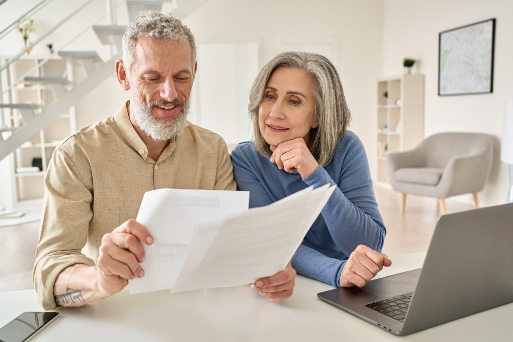 A couple is reading a tax return. They are about to use the tax refund links on the Emerald Financial Partners site.